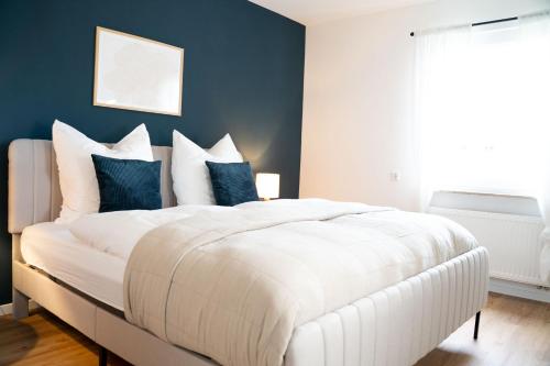 沃尔夫斯堡Gemütliches Design Appartment in Wolfsburg的卧室配有白色大床和蓝色的墙壁