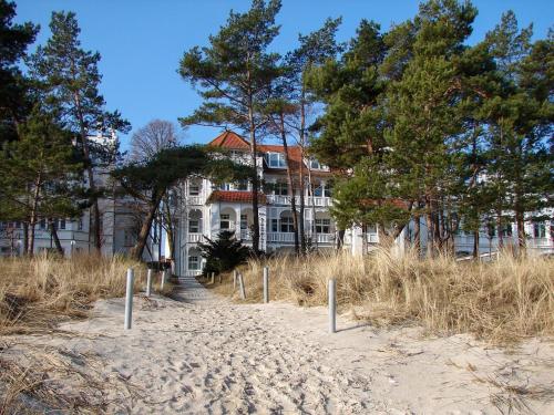 宾茨Villa Strandidyll Apartment 3, Balkon mit Meerblick的海滩前有树木的大型白色房屋