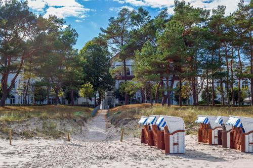 宾茨Villa Strandidyll Apartment 3, Balkon mit Meerblick的沙滩上的一排沙滩椅