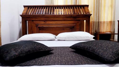 明内里耶Spill View Villa的床上的2个枕头和木制床头板