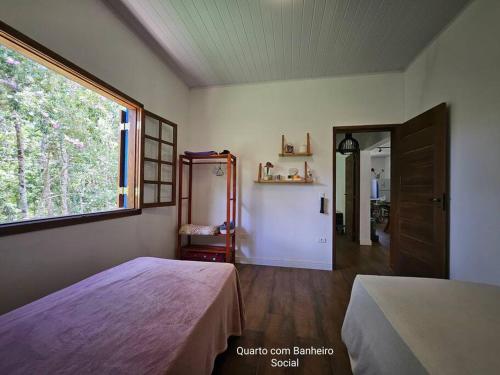 圣路易斯-杜帕赖廷加Sítio O Gajo的一间卧室设有一张床和一个大窗户