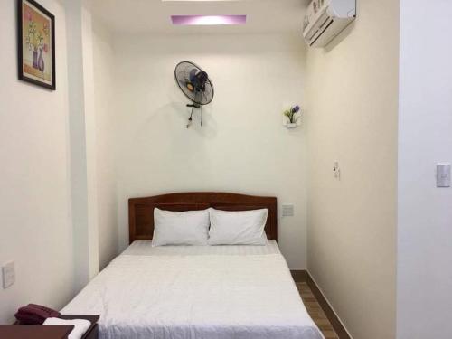 芹苴Nhà nghỉ Nam Anh的卧室配有一张床铺,墙上装有风扇