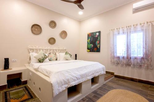布韦朱RoRi Private Luxury Villas的卧室配有白色的床和窗户。