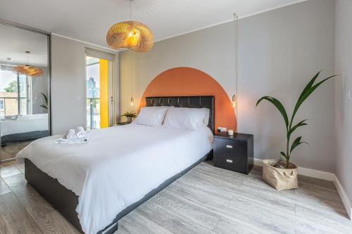 伦敦Lovely 3BR Penthouse wBalconies, Poplar, 2min DLR的卧室配有白色大床和植物