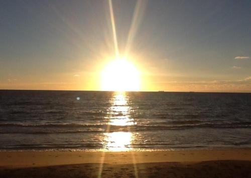 帕诺滩Sunrise Ocean Suites的海滩上阳光灿烂的大海