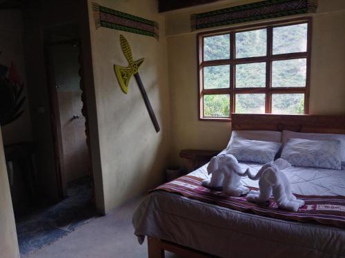 圣特雷莎Salkantay Hostel Chaullay的卧室,卧室的床上有两只狗,设有窗户