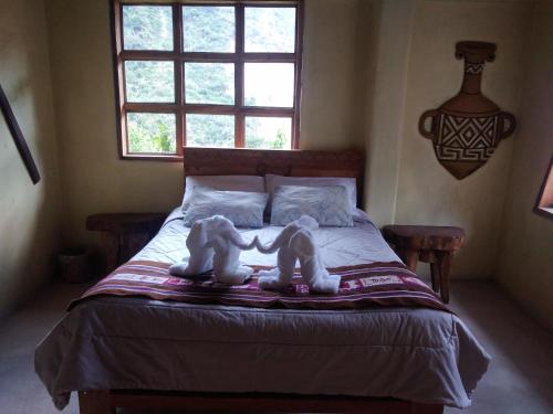 圣特雷莎Salkantay Hostel Chaullay的两只塞满食物的动物坐在床上