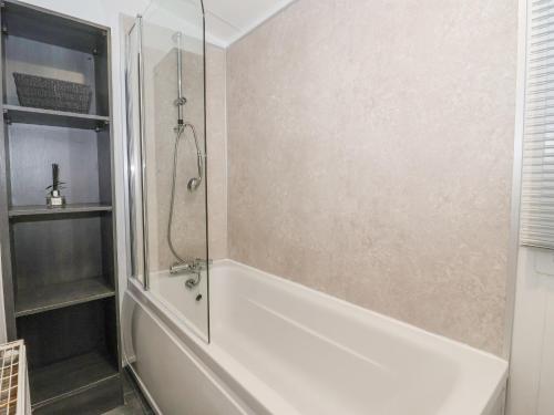 GantonTortworth Lodge的带淋浴和白色浴缸的浴室