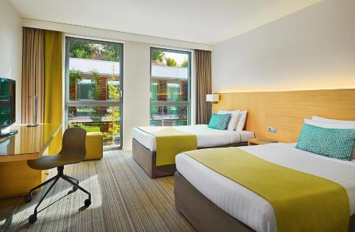 蒙彼利埃蒙彼利埃万怡酒店的酒店客房,配有两张床和椅子