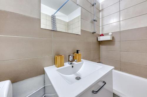 圣但尼Réconfort - 15 min de Paris的白色的浴室设有水槽和镜子