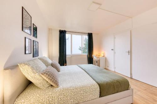 圣但尼Réconfort - 15 min de Paris的一间卧室设有一张大床和一个窗户。