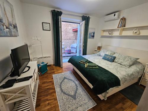 杜布罗夫尼克Dubrovniks best views apartment from a spacious terrace的一间卧室配有一张床和一张书桌及电视