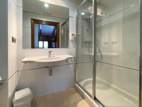 圣多明各德拉Hostal Rey Pedro I的白色的浴室设有水槽和淋浴。