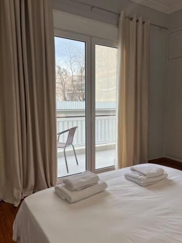 雅典Acropolis Luxury Apartments Parthenon view的一间卧室配有一张床和一个带椅子的窗户