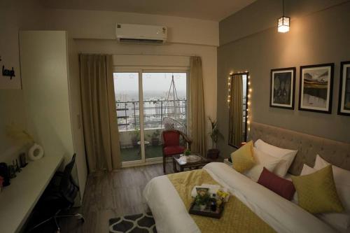 大诺伊达Luxury Apartment Near Pari Chowk的一间卧室设有一张床和一个美景窗户。