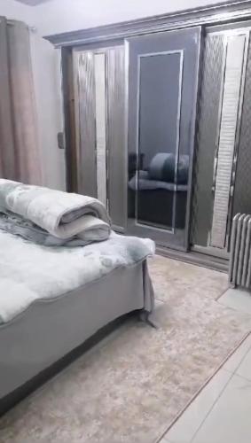 ‘Ezbet el-Auqâtالقاهره ركن حلوان شارع الشهيد的一间卧室配有一张床和一面大镜子
