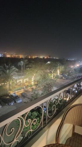 ‘Ezbet el-Auqâtالقاهره ركن حلوان شارع الشهيد的阳台享有夜间停车场的景致。