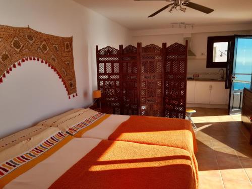 Las Hoyas del BarrancoCerro del Pozo的一间卧室配有一张带橙色和白色毯子的床