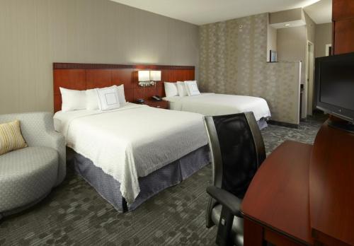 代顿代顿大学万怡酒店的酒店客房,设有两张床和一张沙发