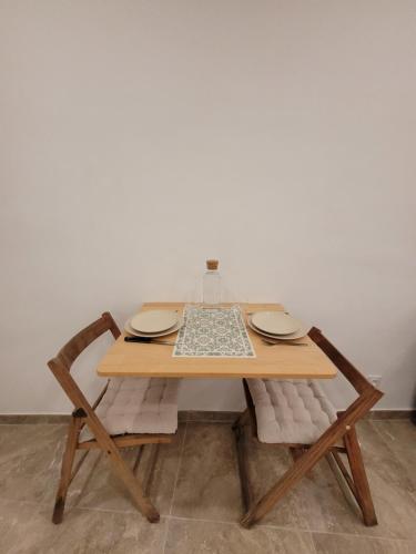 土伦Studio Neuf Centre Historique Halles de Toulon的一张木桌,上面有两盘,椅子