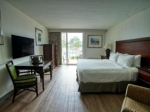 圣徒皮特海滩Treasure Island Hotel and Marina的酒店客房配有一张床、一张书桌、一张床和一张书桌。