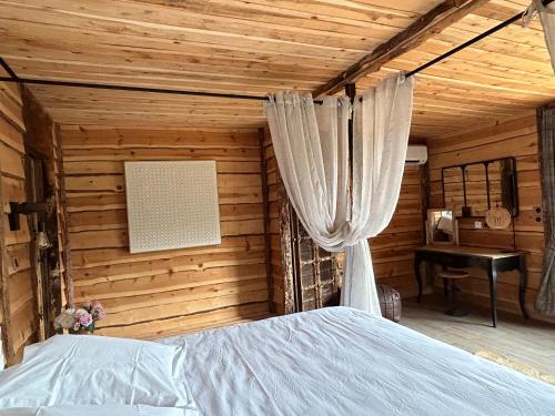 里耶巴斯蒂德马赞旅馆的木制客房内的一间卧室,配有一张床