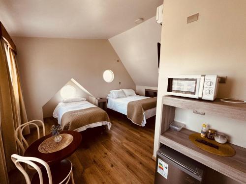瓦尔迪维亚Hotel Casona Los Colonos的小酒店客房设有两张床和一张桌子。