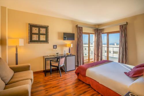 科尼尔-德拉弗龙特拉安达露西亚酒店的配有一张床和一张书桌的酒店客房