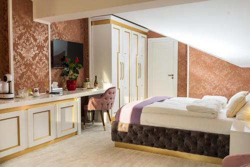 诺维萨德Queen Palace的配有一张床和一张书桌的酒店客房