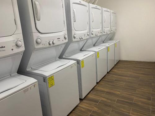 布塞里亚斯Refugio del Mar Luxury Hotel Boutique的客房内的一排白色洗衣机和烘干机