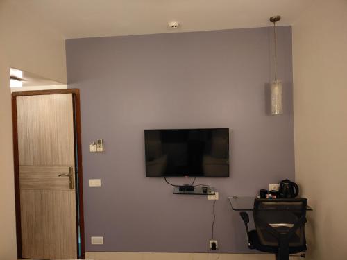 孟买Apollo Guest House的墙上配有平面电视的房间