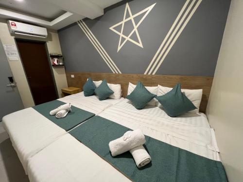 关丹KUANTAN BESERAH BUDGET HOTEL的一张带枕头和毛巾的大型白色床