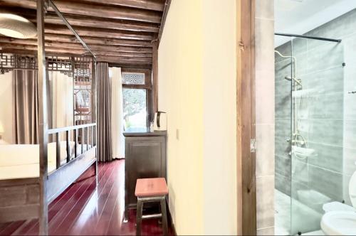 大理清心庭院百年民宿艺术客栈的浴室设有玻璃淋浴间和凳子