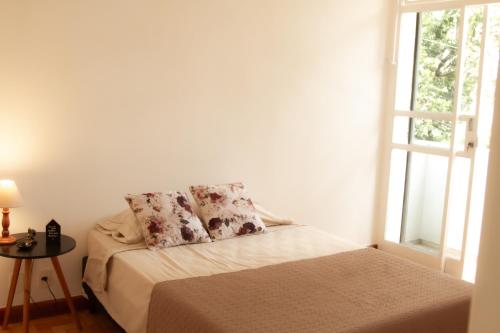 贝洛奥里藏特Apartamento Gutierrez 2的一间卧室配有带两个枕头的床和窗户