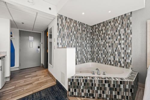大洋城Hotel Monte Carlo Ocean City的带浴缸和瓷砖墙的浴室