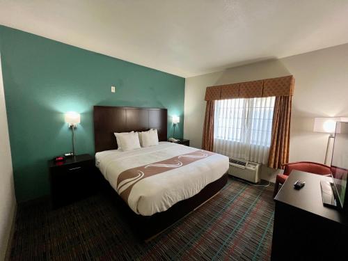 韦科近大学质量酒店及套房的酒店客房设有一张大床和一张书桌。