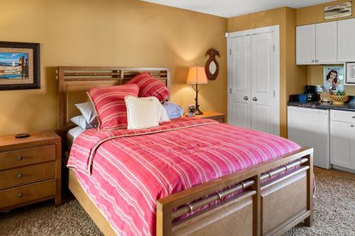 基黑Studio Boutique Resort Across from Beach的一间卧室配有一张带粉红色棉被的大床
