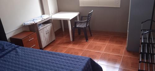 瓦努科DEPARTAMENTO CON 3 DORMITORIOS的卧室配有1张床、1张桌子和1把椅子