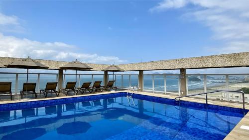 桑托斯Parque Balneário Santos by Atlantica Hotels的一个带椅子的游泳池,享有海景