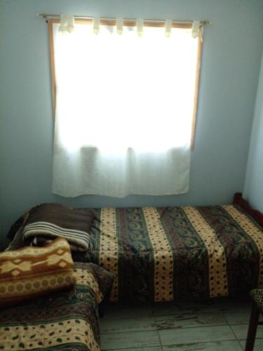 GualeguaychúLa Delia的一间卧室设有两张床和窗户。