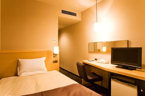 盛冈盛冈大都会酒店的酒店客房配有一张床和一张带电脑的书桌