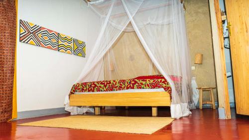 RuhengeriRoom in Guest room - Isange Paradise Resort的一张带天蓬的床