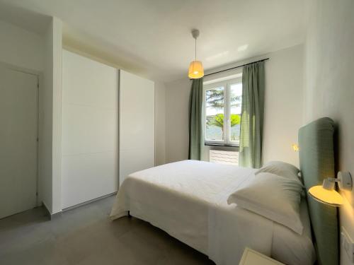 莫内利亚Podere Belvedere的卧室配有白色的床和窗户。