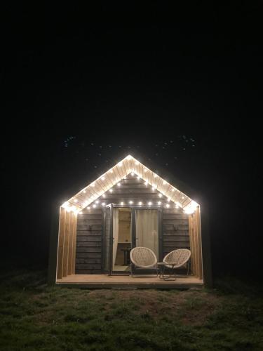 克拉斯特Craster Coastal Cabins的小屋配有两把椅子和灯