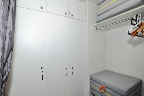 斯托纳姆22#31 Chemin du Hameau - Studio的白色衣柜,带白色橱柜和灰色的箱式凳