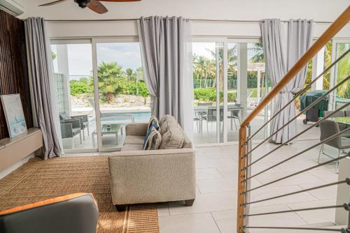 Long Bay HillsVillas with Private Pool 5 min to Grace Bay beach的带沙发的客厅和阳台