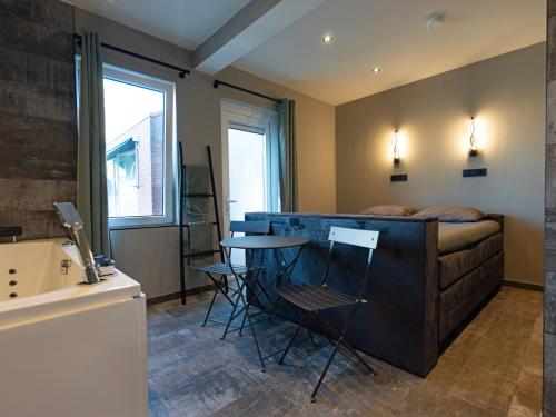 奥德多普Luxe kamer B&B Gezond aan Zee, met jacuzzi en stoomsauna, de wellnestuin buiten is te huur voor privé gebruik tegen meerprijs的卧室配有一张床和一张桌子及椅子