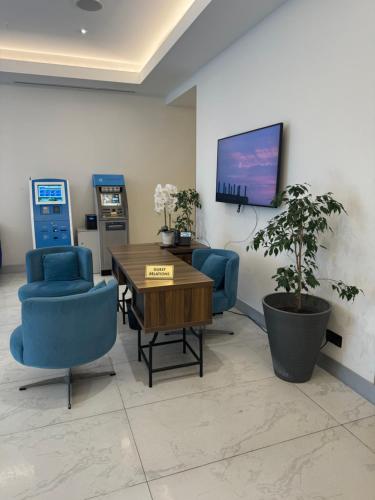 巴统Orbi city - Premium Class Rooms的一间设有桌椅和电视的等候室
