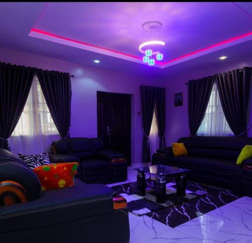 伊巴丹D'EXQUISITE APARTMENTS的紫色的客厅配有沙发和桌子