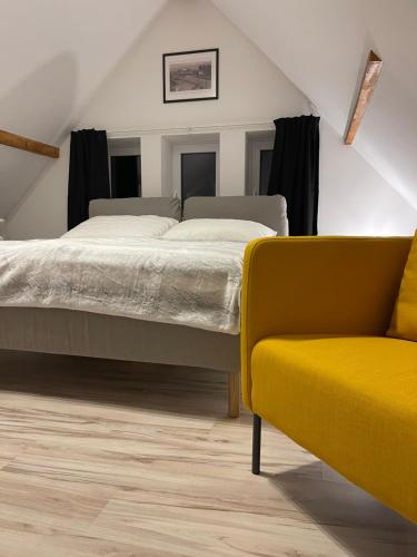 扬斯凯拉兹涅Apartmánový dům Jánský sen的一间卧室配有一张床和一张黄色椅子